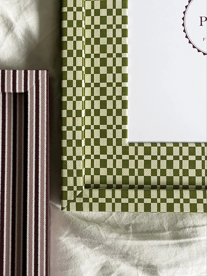 Green & Beige Checkered Frame, a colourful frame sitting on a plain white surface.  It is joined by another colourful frame. 