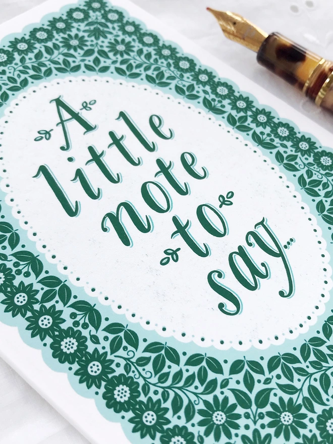 green hand lettered notecard with a little note to say in green floral pattern with fountain pen