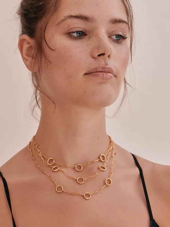 woman wearing three necklaces