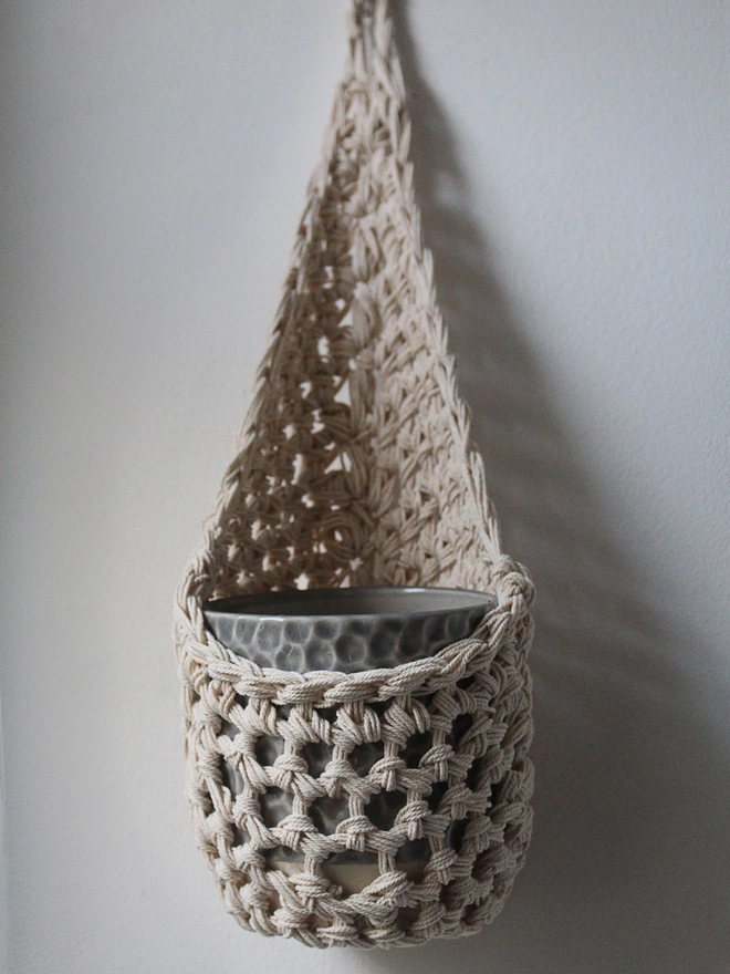 cream ivory indoor hanging plant basket handmade wall planter porch decor, indoor small ecru jute hanging wall planter, cream fabric wall mounted plant holder, handmade crochet plant basket, handmade sustainable crochet decor, rustic natural organic homeware accessories, ivory hanging plant holder