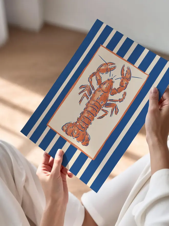 Lobster stripe art print being held in a woman's hands. 