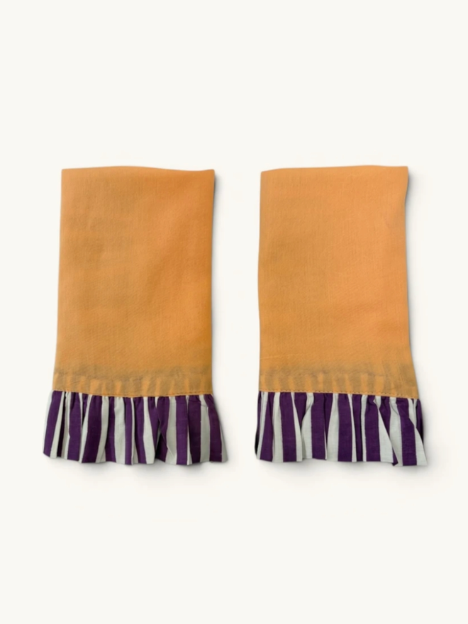 Pair of Ruffle Napkins. A pair of napkins, folded, in peach and violet.