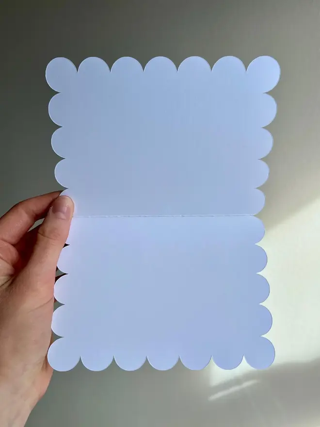 illustrated dinosaur birthday card. scallop edged card open to show blank inside.