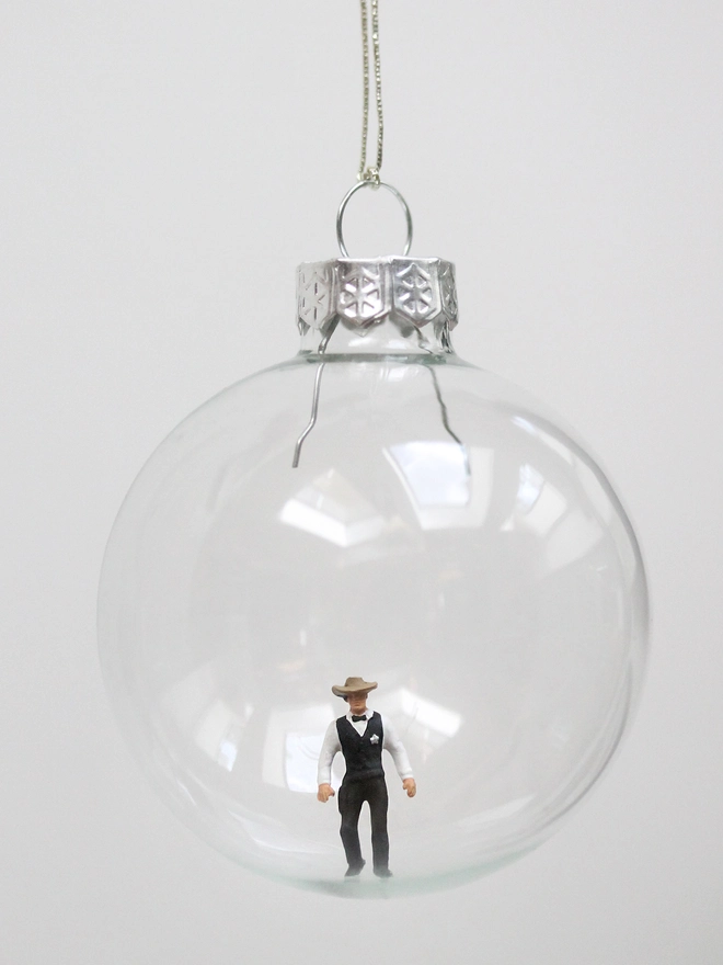 miniature cowboy/sheriff figure in a glass christmas bauble