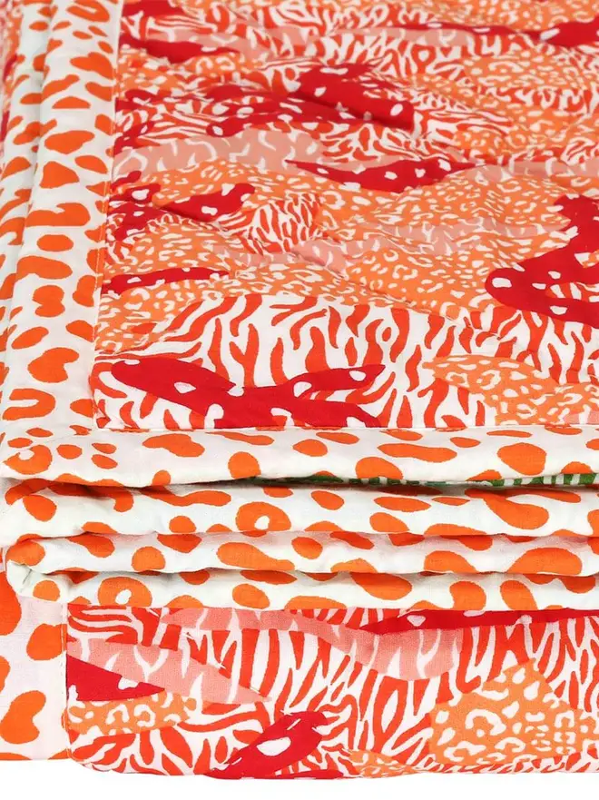 Big Cat Camo Quilt, a pink and green quilt on a bed in a bedroom. 