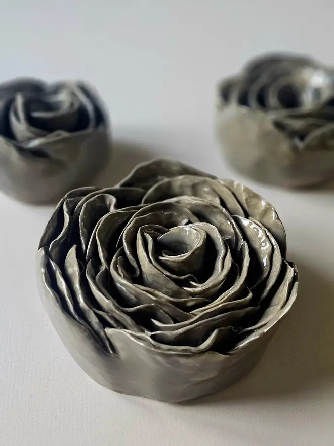 Handmade ceramic rose sculpture with a gray/greenglossy glaze, crafted in 3D and designed to hang on a wall