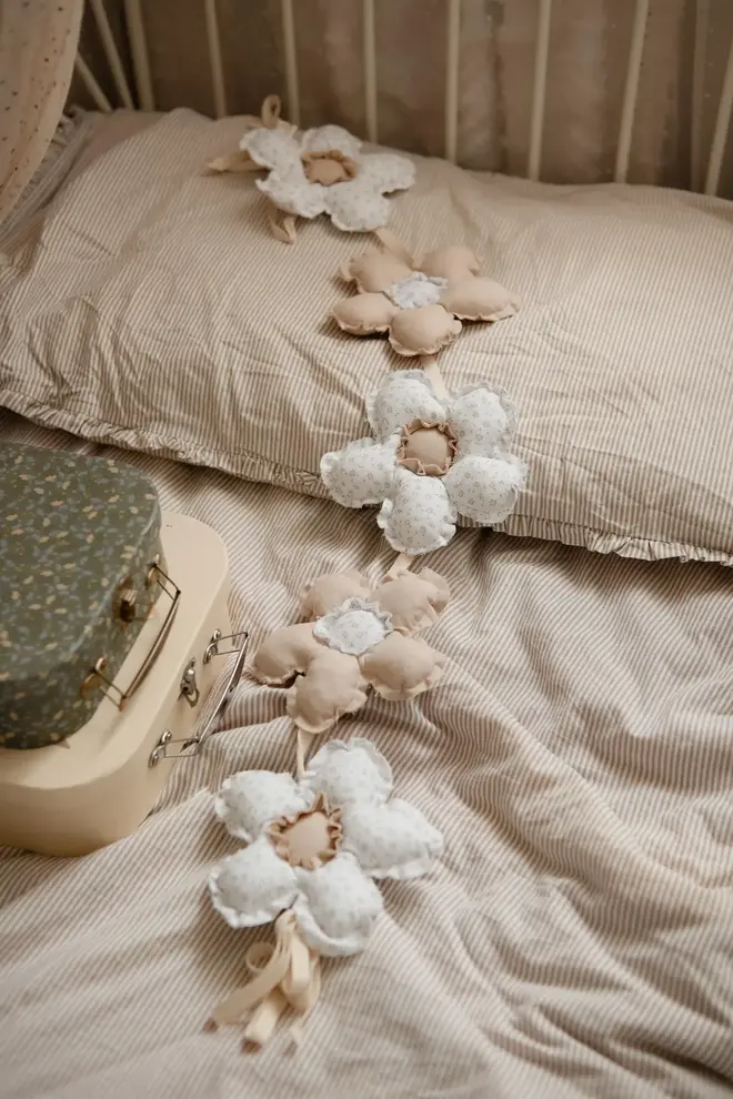 Daisy Flower Garland Decoration, a hanging colourful daisy flower garland sitting in a child's bedroom. 