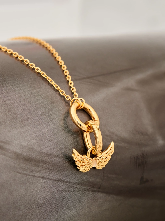 gold necklace with Hermes wings charm