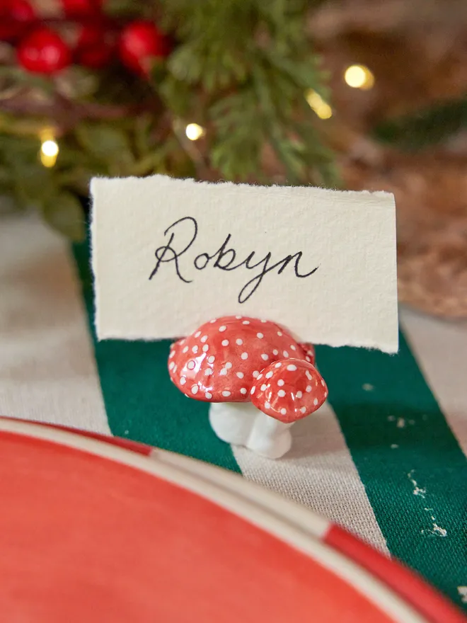 A Toadstool name card holders red and white places on a chritsmas set up table 