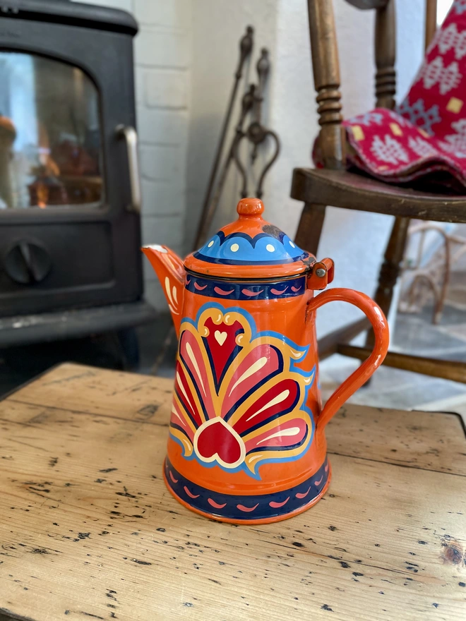 Orange vintage coffee pot, hand painted with a fairground inspired design in pink, red, orange, yellow and blue.
