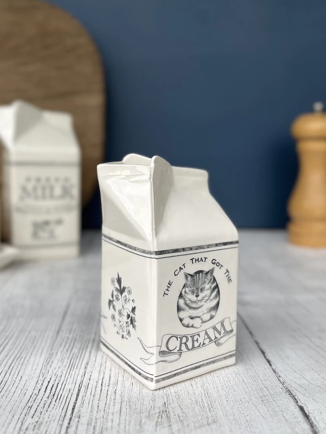 A handmade jug that emulates a paper carton, decorated with Beatrice von Preussen Illustrations.