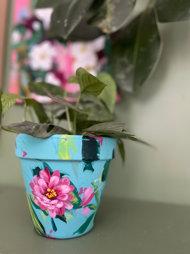 Hand painted floral pot in pale teal background bright pink zinnia flowers 