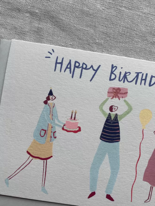 birthday card with people celebrating with cake, presents and balloons