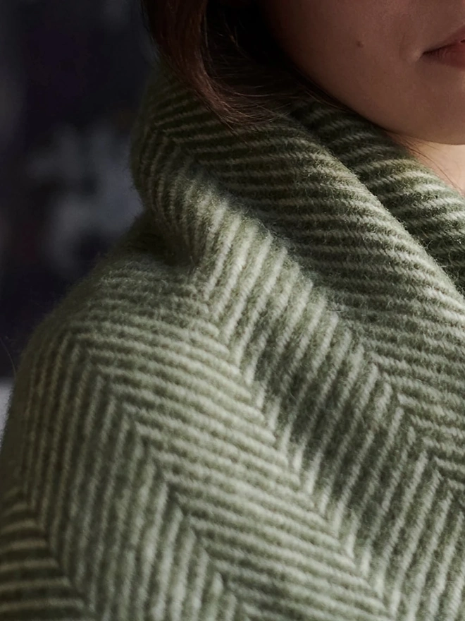 Organic Wool Throw, a person with the wool throw draped over them. 