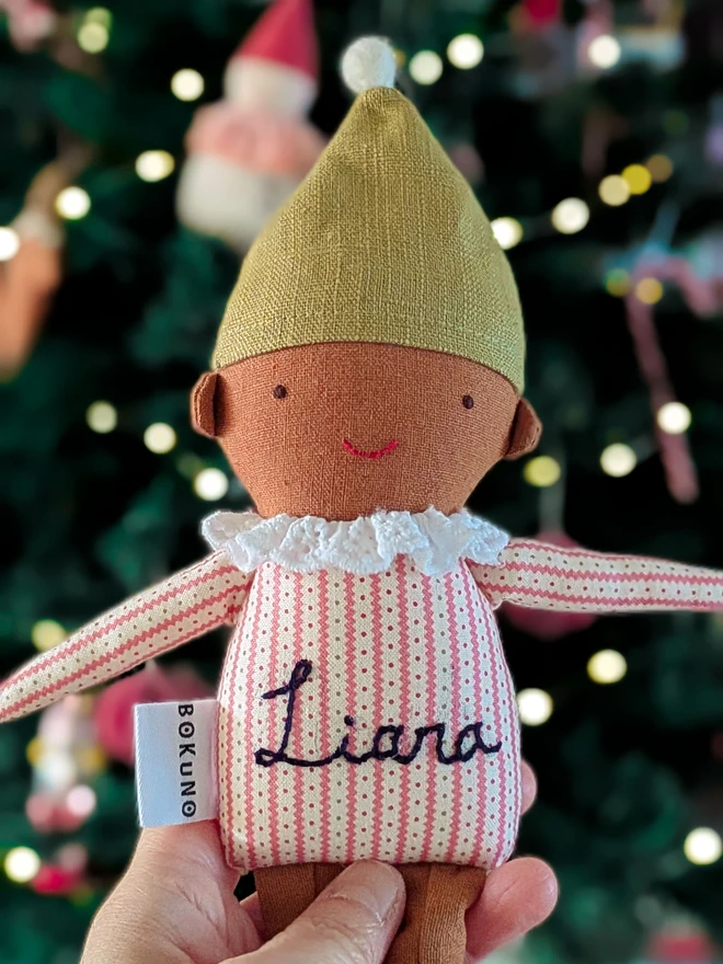 handmade elf doll in stripe top and green hat with a name embroidered, with brown skin tone. 