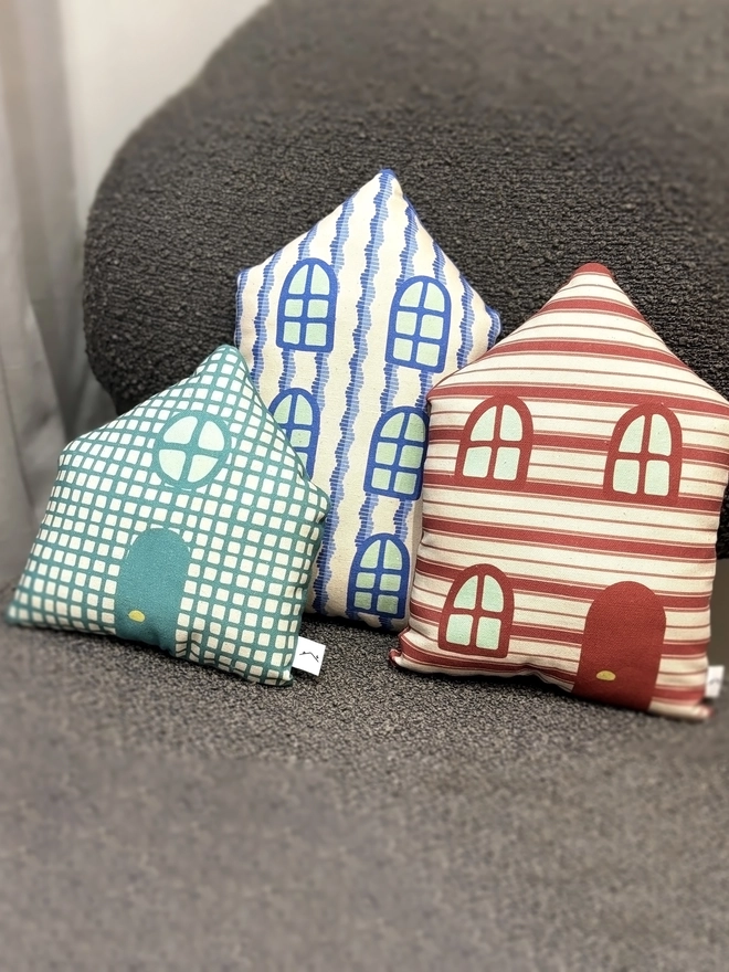 Front of Set of 3 house cushions lying on a brown chair