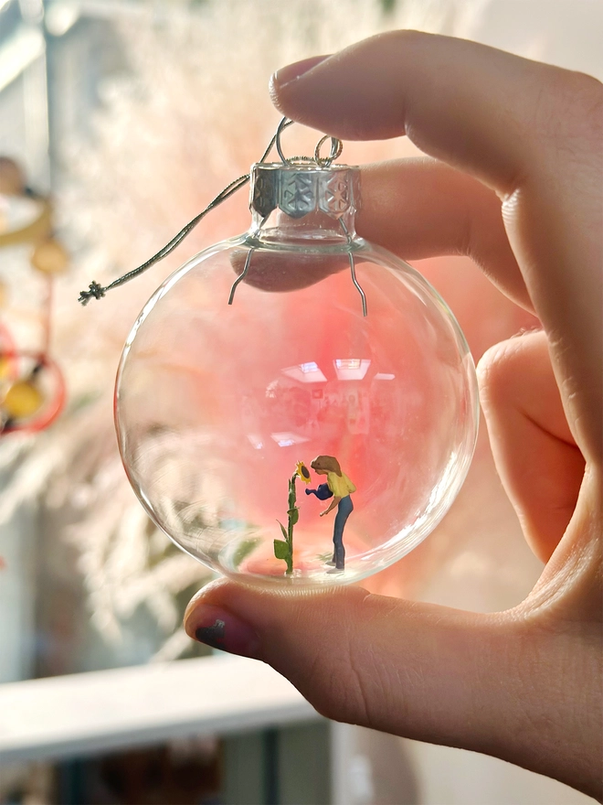 Miniature glass bauble containing a tiny figure in artist's studio