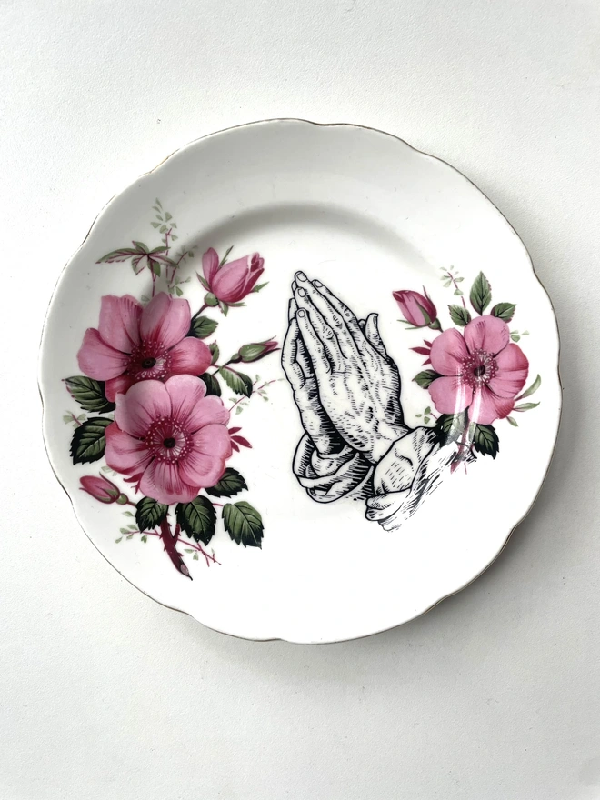 a vintage ornate plate that has pink flowers on and in the centre i have print a black and white illustration of 