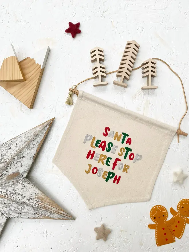 personalised embroidered santa stop here banner. cotton banner embroidered with festive colours.