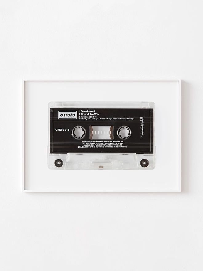 oasis wonderwall cassette tape print. framed print hung up on white wall.