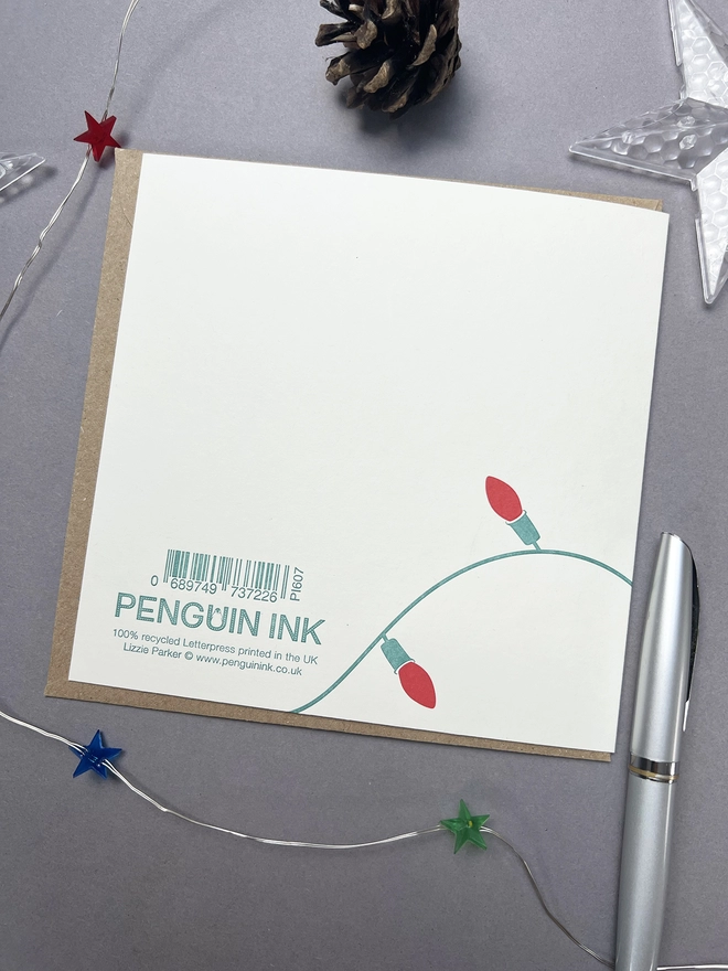 Back of the card with some fairy lights and the Penguin Ink logo and barcode