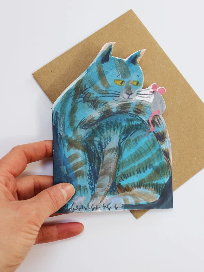Hand holds shaped greetings card showing blue striped cat
