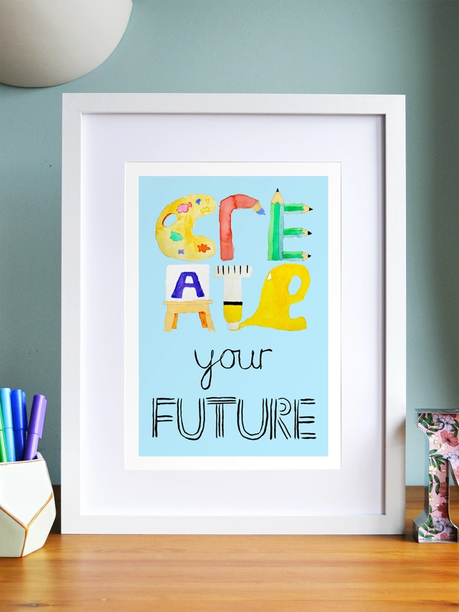 Art print saying 'Create your future' in a white frame in a child's room