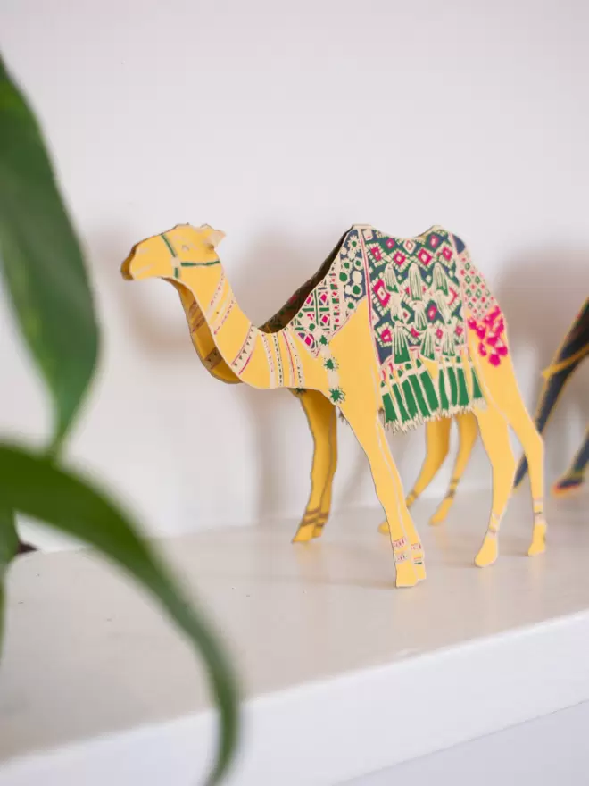Full shot of image of yellow camel displayed on shelf