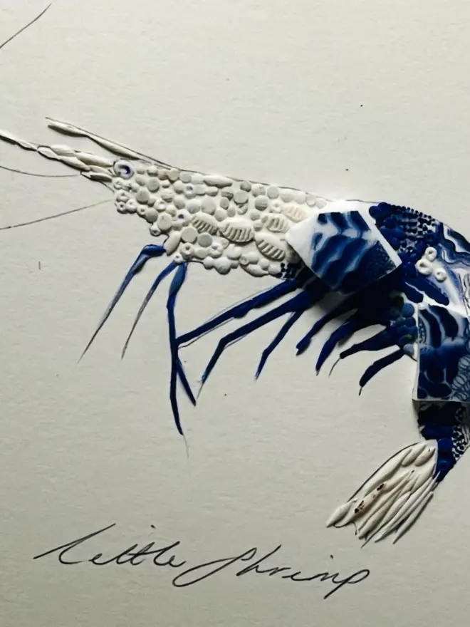 Hand-drawn, painted, mosaic clay, blue vintage Chinese Willow Tree pottery insect on white double mounted card, in a black circular frame.