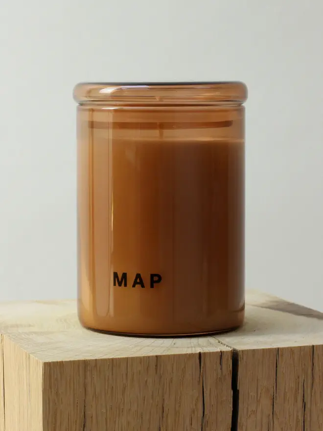 calm aromatherapy candle and home fragrance spray set. candle photographed on wooden surface. 