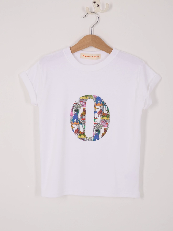  a personalised kids white t-shirt with an initial cut from liberty dinosaur print on the front