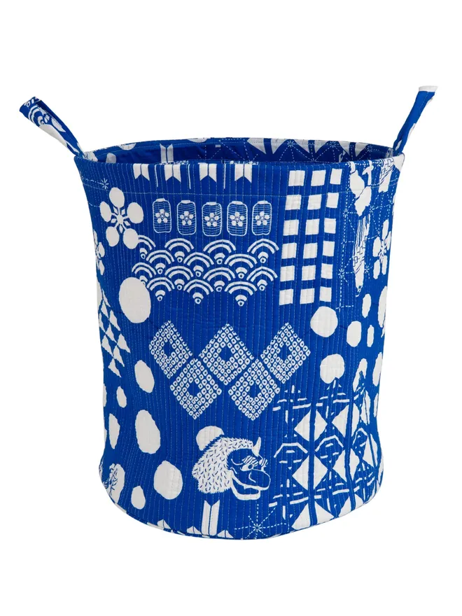 Blue Festival Quilted Storage Basket, a blue basket sitting against a white backdrop. 