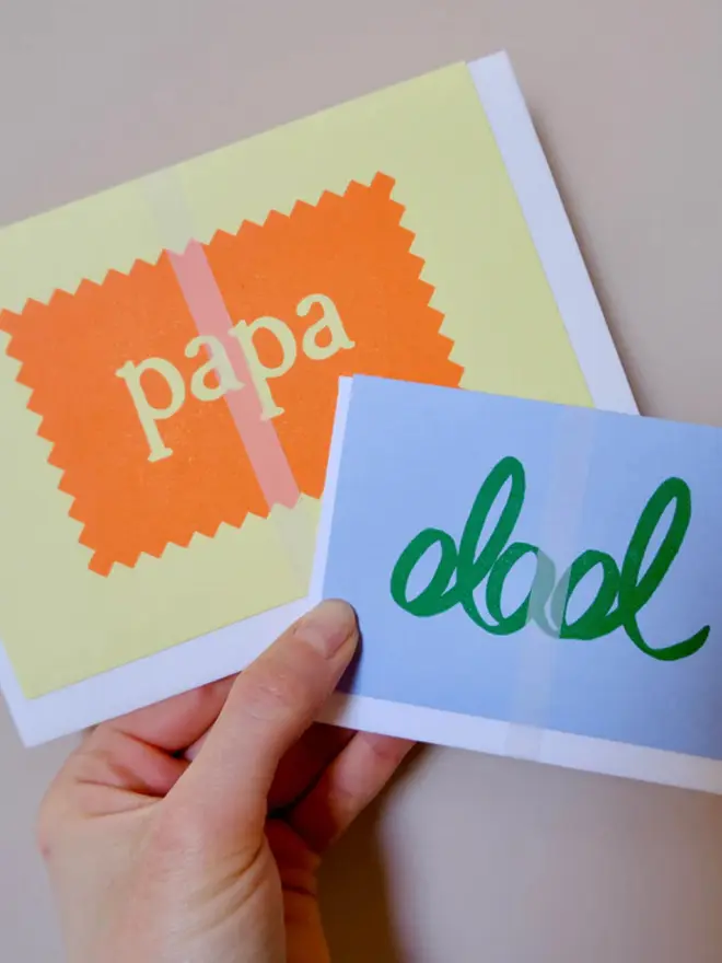 'Dad' hand printed in green on a blue card. 