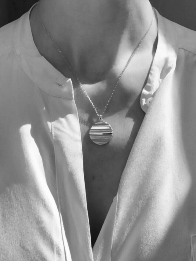 black and white image of a beautiful silver coin pendant