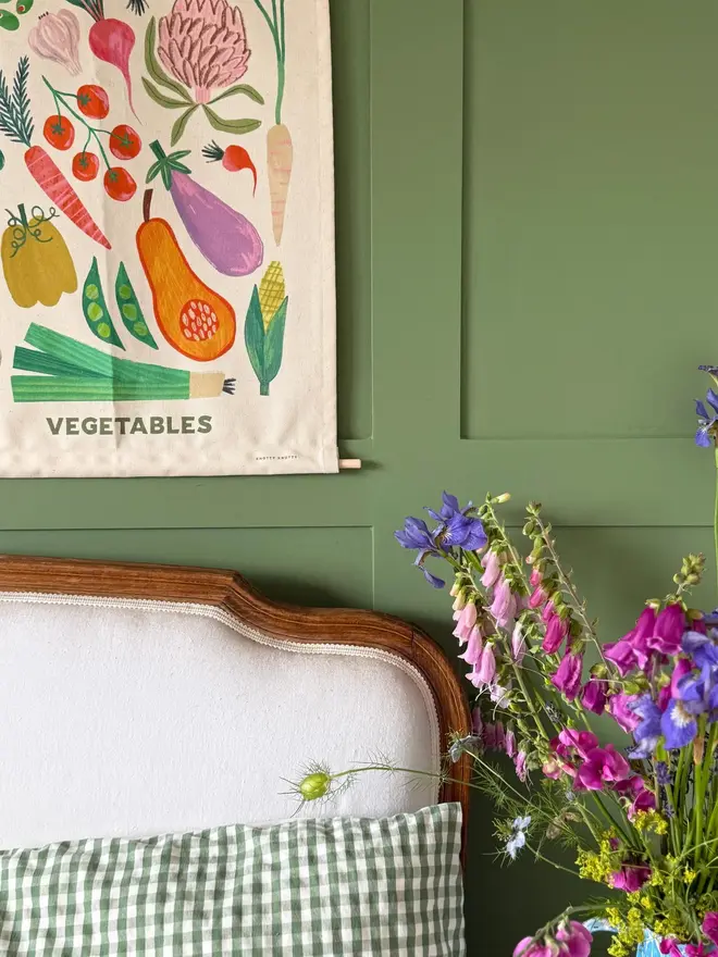 Vegetable Print Fabric Banner, against a green wall. 