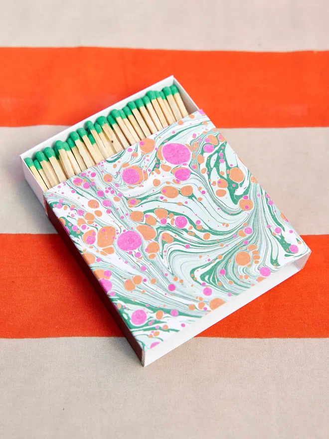 matchbox with blue green and pink marbled cover