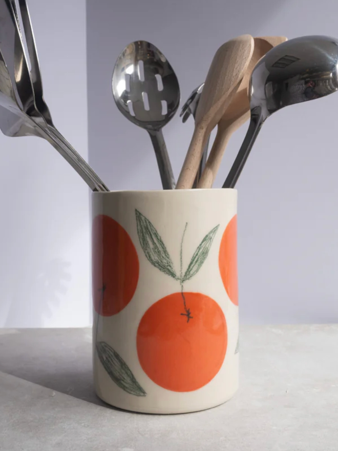 Utensil Holder. A utensil holder with an orange design.