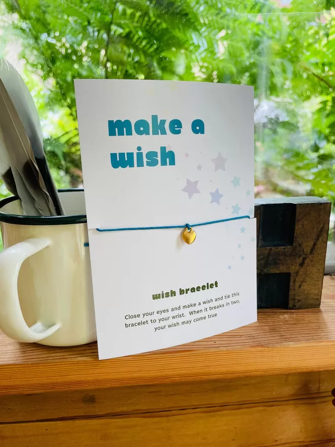 Make a wish bracelet on a presentation gift card on a shelf.
