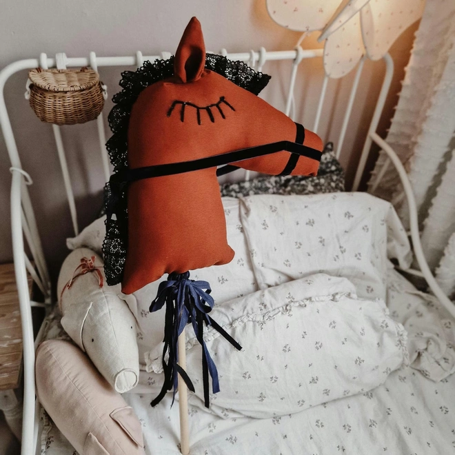 Handmade Cotton Hobby Horse Nursery Decoration, a cotton hobby horse sitting in a child's bedroom surrounded by other bedroom accessories. 