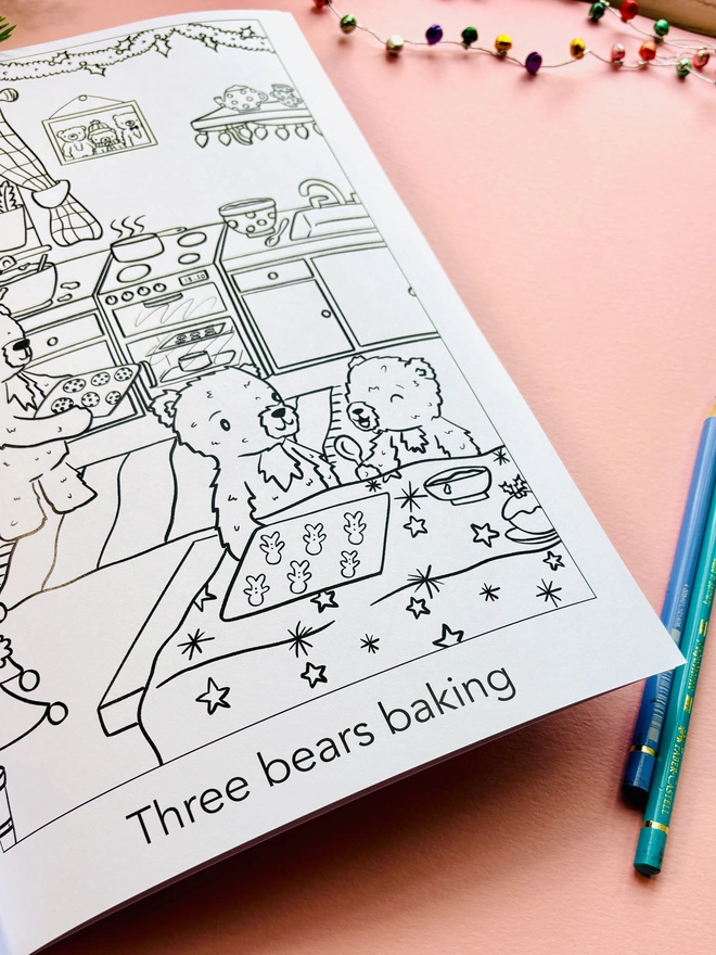 Christmas colouring book displayed with crayons and festive decorations.