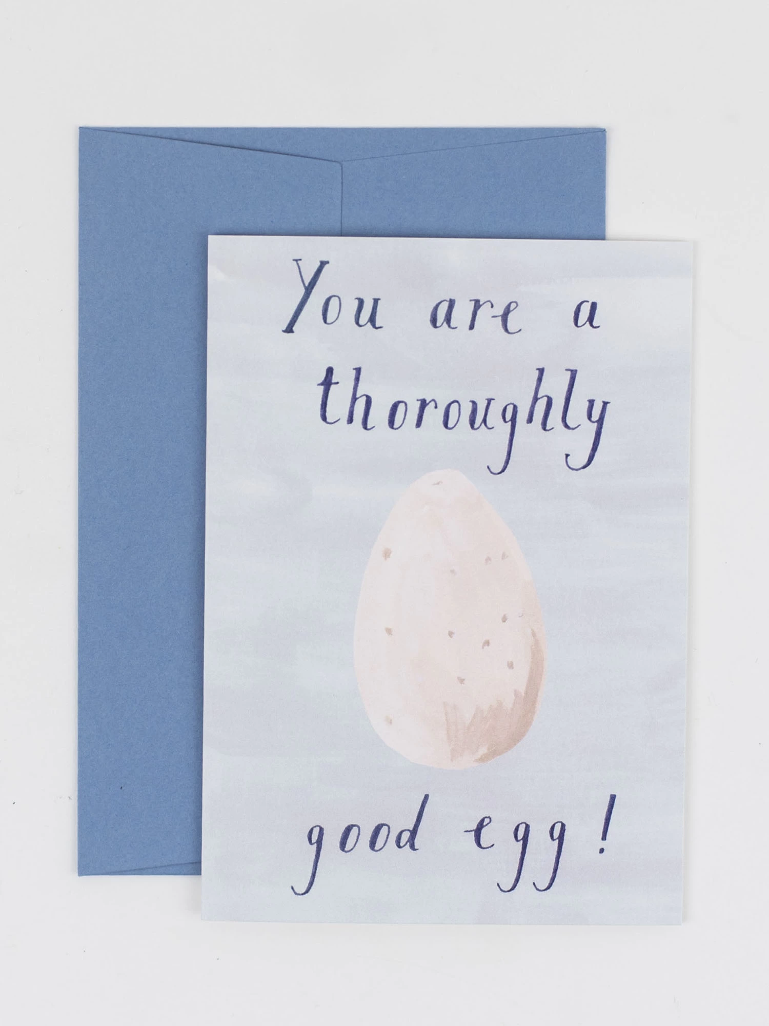 A card featuring an illustration of an egg and the words "you are a throughly good egg". Photographed with a pale blue envelope
