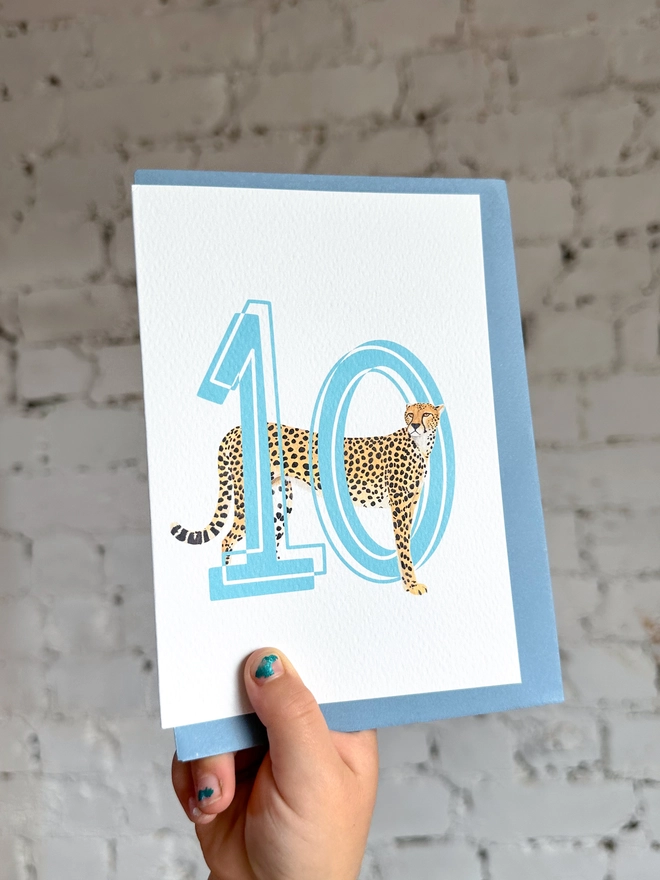 a white card with a big blue number 10 and an illustration of a cheetah with a pale blue envelope