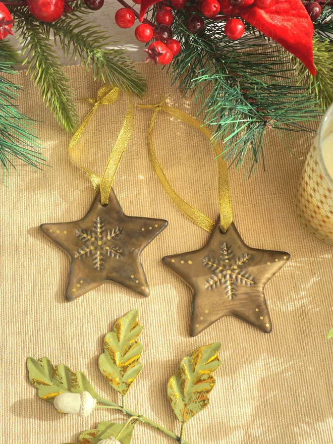 Star Christmas decorations, ceramic decorations, dream catcher, christmas star, pottery, Jenny Hopps Pottery, J.H Pottery, J.Hopps Pottery, Clay star, gift, christmas tree, blue with white and cream with gold details, on a light gold ribbon, photographed on a branch with Christmas lights, ceramic gifts for her, gifts for mum, gifts for sister, gifts for friend, gifts for girlfriend, gift for dad, ceramic gift for dad, gift for husband, gift for son, gift for teens, gifts for teenagers, gift for home, homeware gift, 