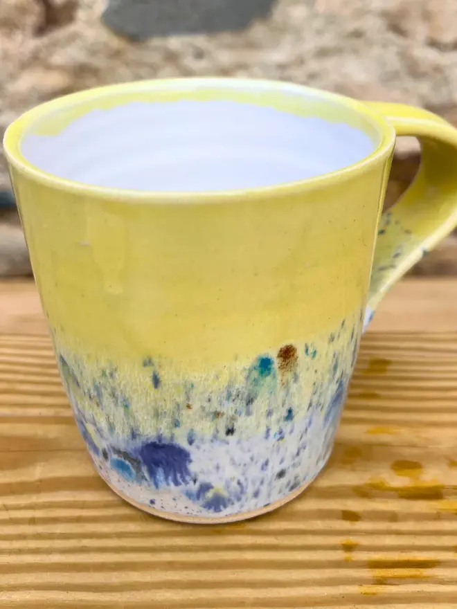 Shoreline Standard Mug, a colourful mug placed on a wooden surface. 