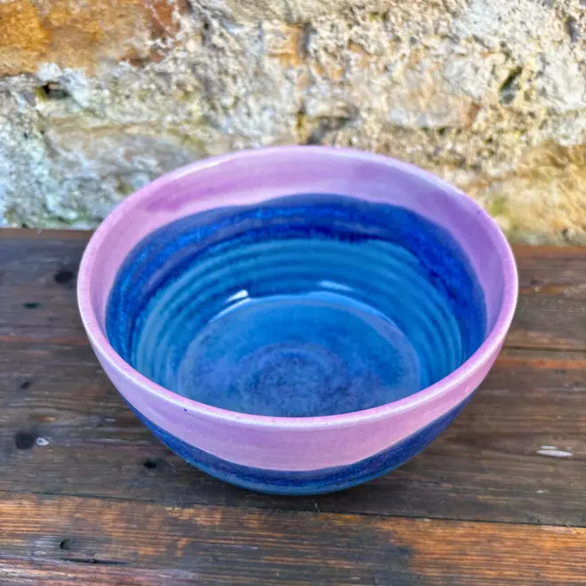 Landscape Ramen Bowl, a of colourful ramen bowl placed on a wooden surface in front of a brick backdrop. 