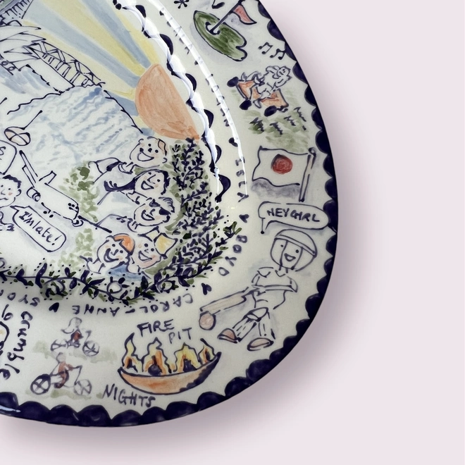 Close up detail on the end of a hand-painted platter with people, places and scenes that make up memories to the receiver