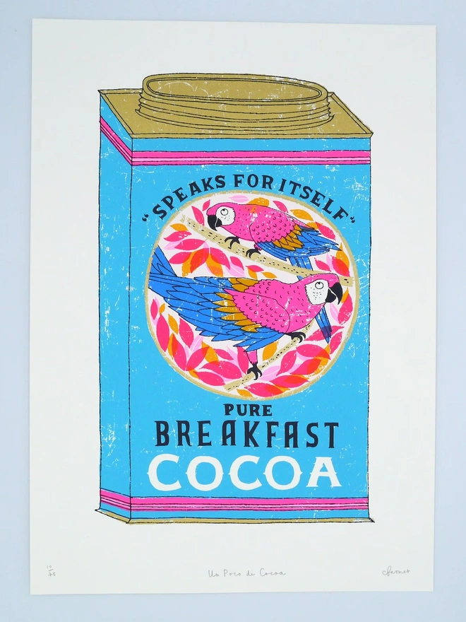 Vintage Parrot Cocoa Tin Un Poco De Cocoa, a colourful cocoa tin screenprint against a baby blue background. 