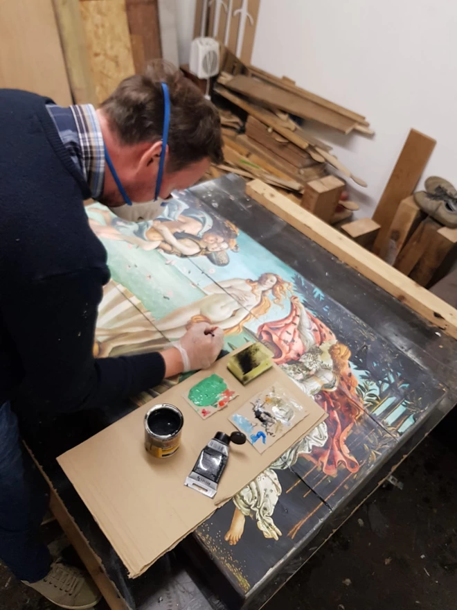 a man adding paint to enhance artwork depth
