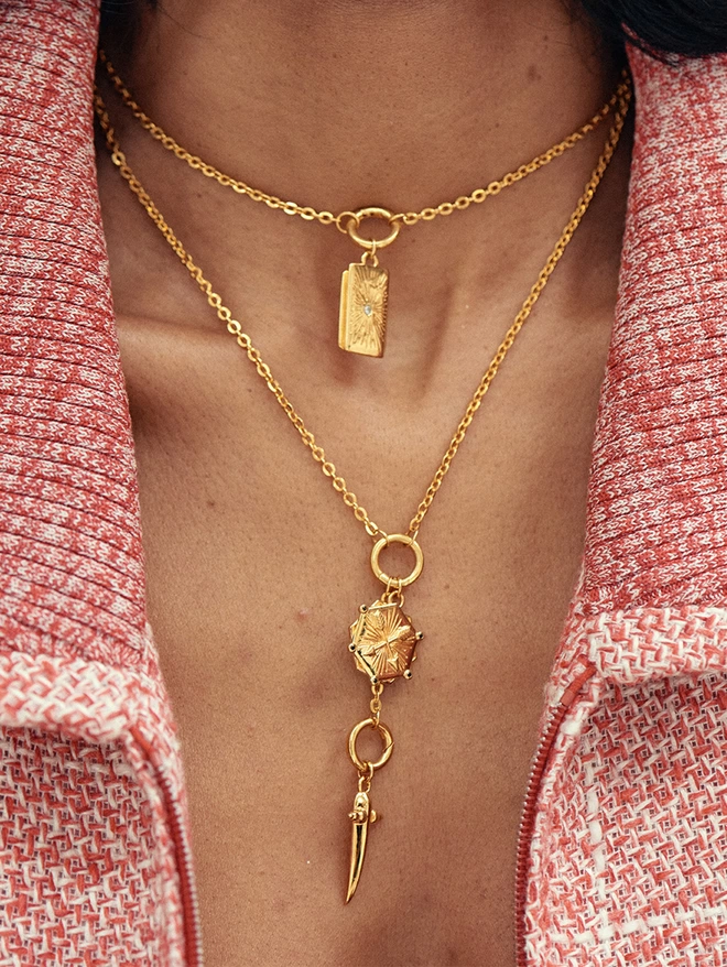 woman wearing a gold necklace with pendants and charms