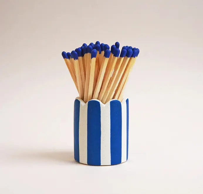 Stripy Match Stick Holders. Coloured matchsticks in a striped, scalloped matchstick holder on a white background.  